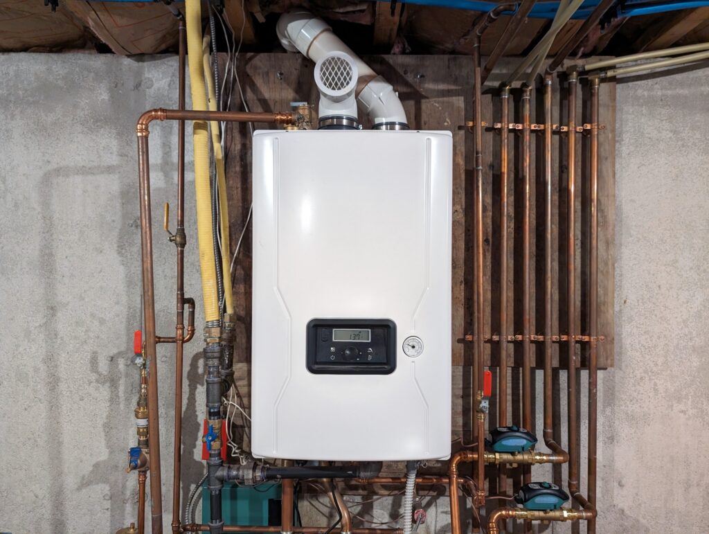 Tankless water heater surrounded by copper pipes