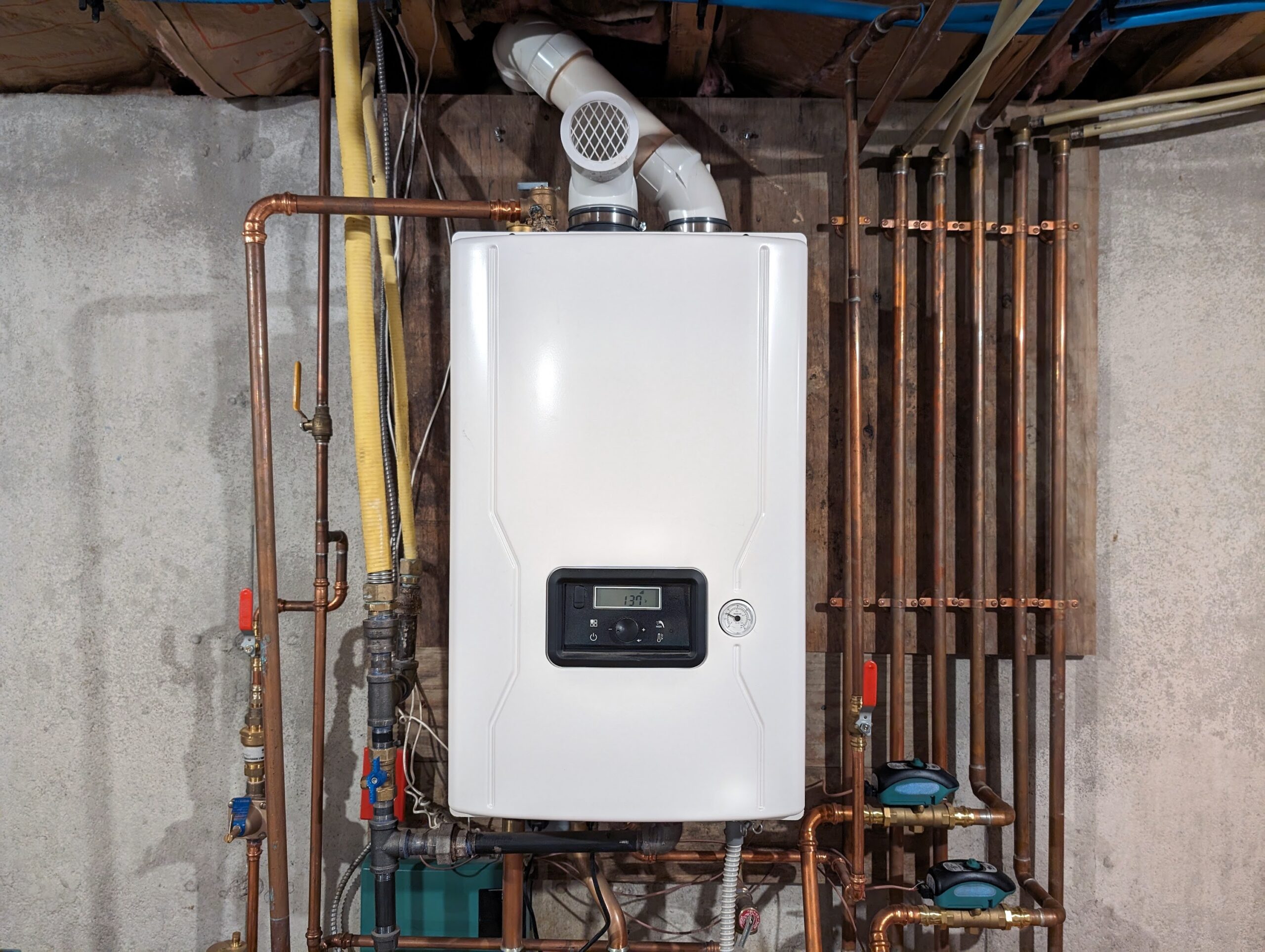 Tankless water heater surrounded by copper pipes